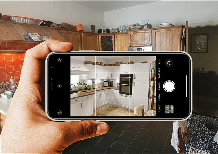 A person taking a photo of a kitchen using the Kitchen Selfie app on their smartphone